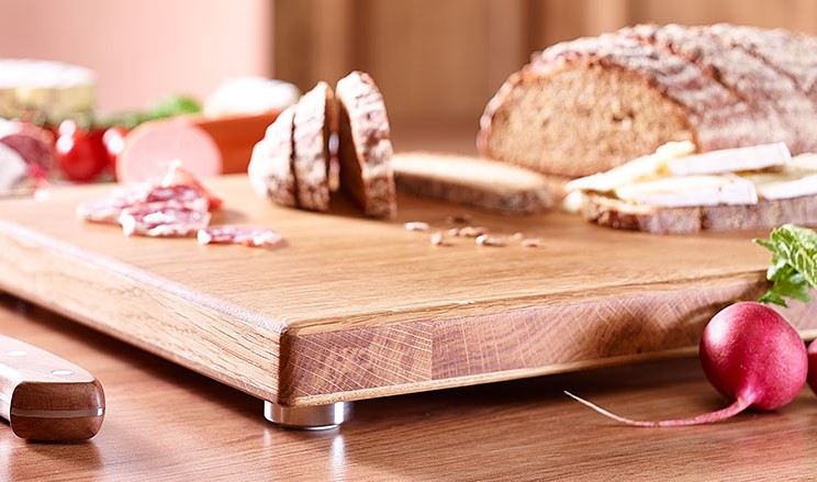 Schneidebrett Eiche mit Messer, Radieschen, geschnittenem Brot auf Arbeitsplatte