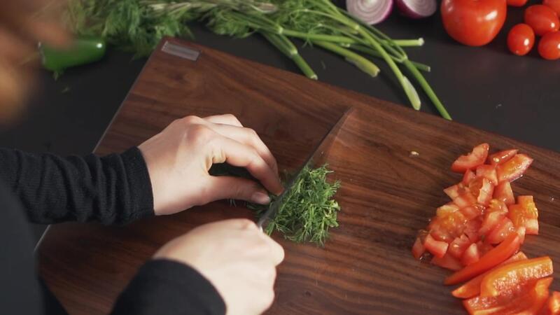 Schneidebrett Nussbaum auf dem Kräuter und Tomaten geschnitten werden